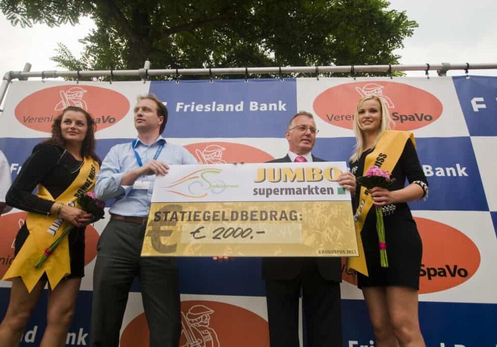 Namens de Surhuisterveense Jumbo overhandigt Ruben Vogd de cheque aan vice-voorzitter Albert Helfrich van het wielercomité.